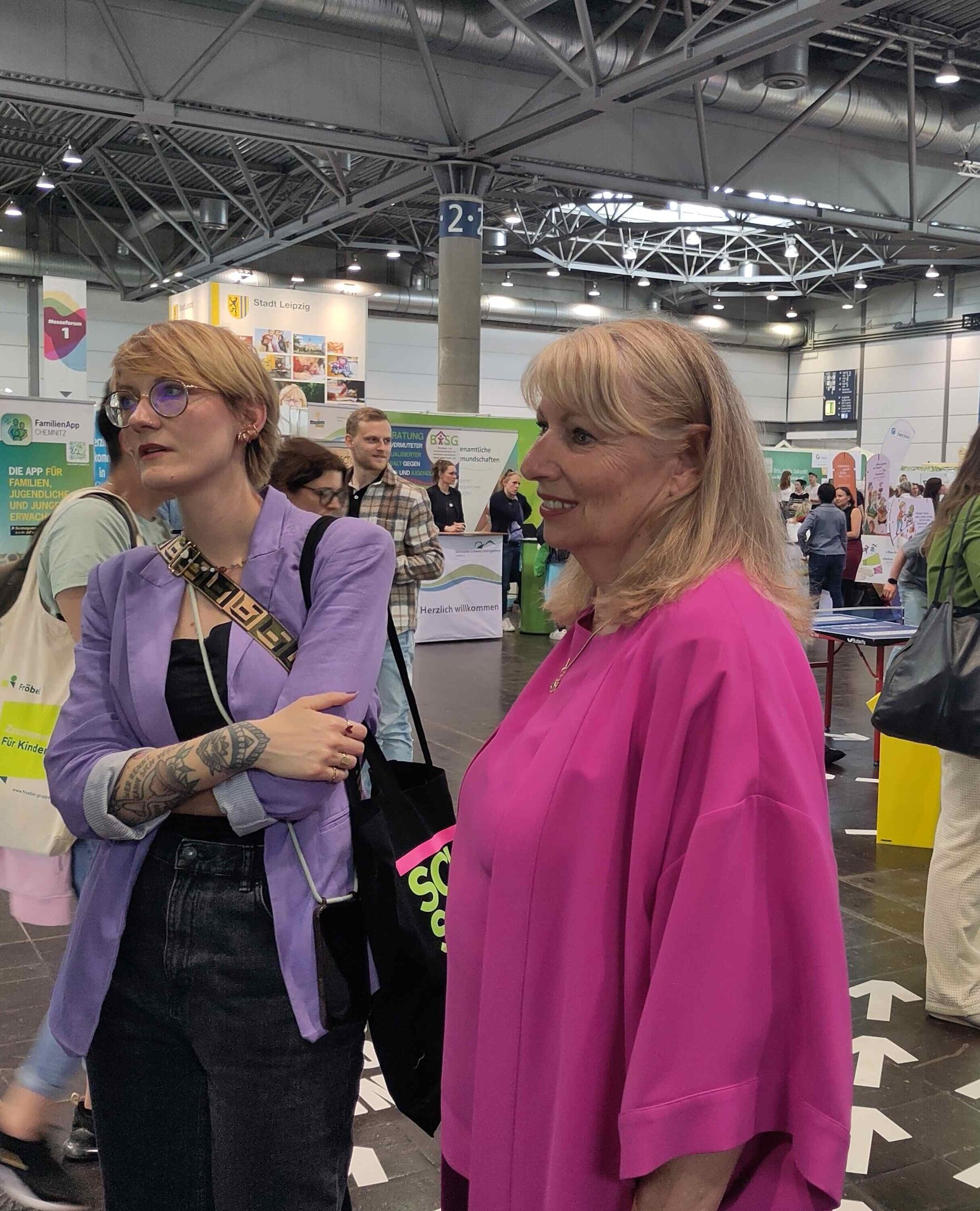 Auf diesem Foto ist die Sozialministerin Petra Köpping zusammen mit der Abgeordneten Sophie Koch zu sehen. Beide schauen gespannt aus dem Bild heraus in Richtung des Monitors. Dort wird ein Film des Wettbewerbs 3mal10 vorgestellt.