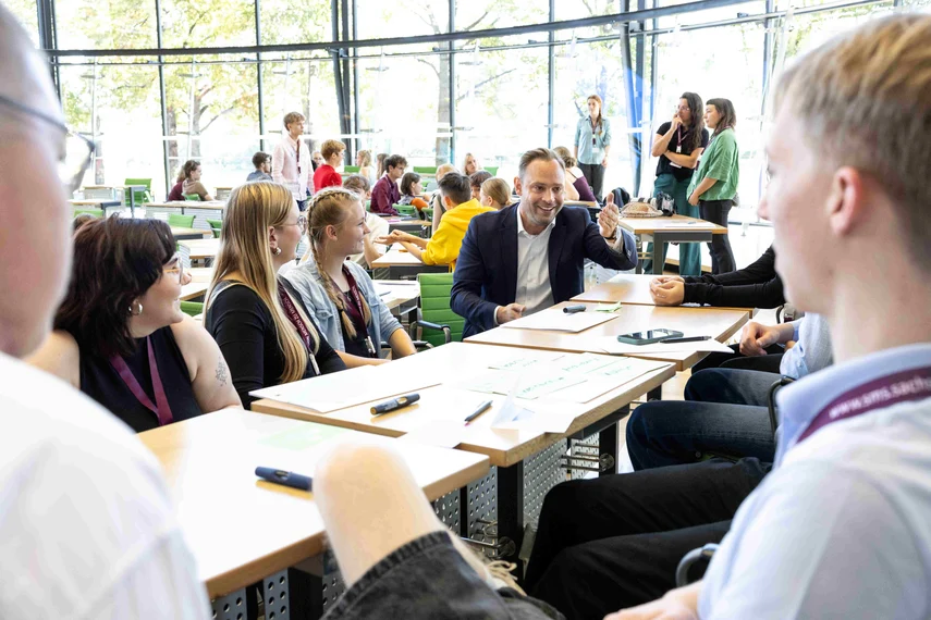 Junge Menschen sitzen am Tisch und sprechen