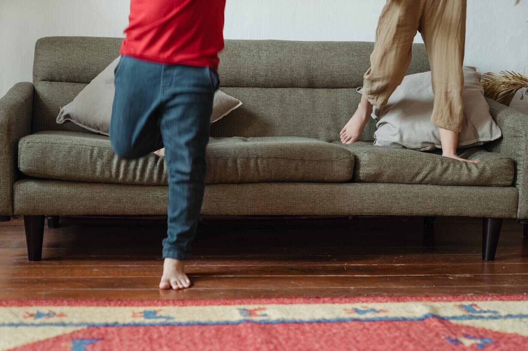 Kinder springen von einem Sofa