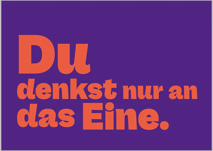 Postkarte mit orangefarbenem Text auf lila Hintergrund: »Du denkst nur an das Eine.«