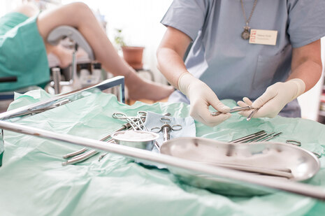 Eine Gynäkologin bereitet ihr Instrument für den chirurgischen Schwangerschaftsabbruch vor (Gestellte Aufnahme)