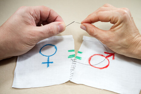 Zwei Hände nähen ein zerissenes Stück Stoff mit einem weiblichen und männlichen Symbol zusammen