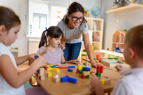 Erzieherin spielt in einer Kindertageseinrichtung mit Kindern