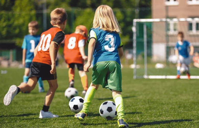 Kinder spielen gemeinsam Fußball